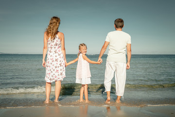 Happy family standing at the beach at the day time