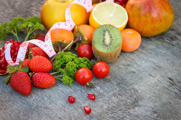 Fototapeta na wymiar Fruits, vegetables and in measure tape in diet