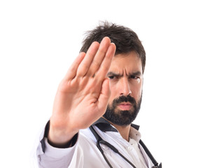 Doctor making stop sign over white background