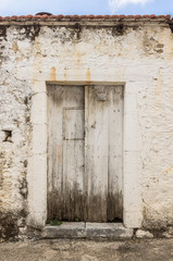 Old white timber door in the scuffed wall