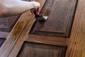 The carpenter is painted beautiful wood doors.