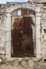 Old white rusty door in the scuffed wall