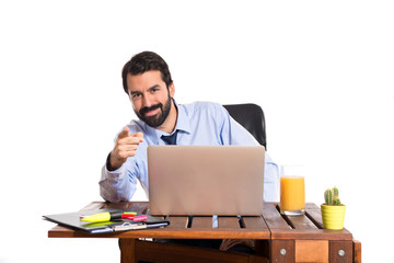 Businessman in his office pointing to the front