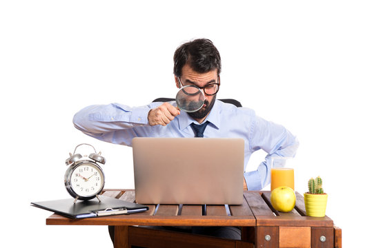 Businessman in his office with magnifying glass