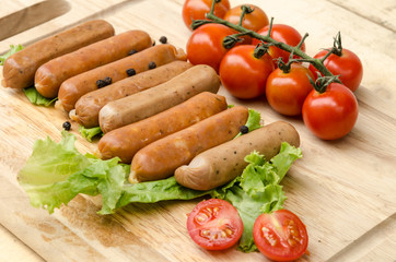 sausages and tomato on chopping board
