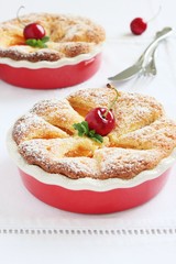 Apricot cake with sweet cherry and whipped cream garnish.