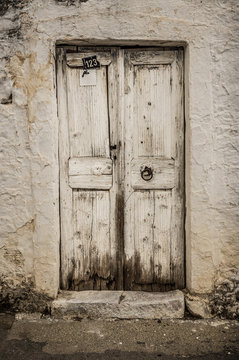 Old white timber door in the scuffed wall