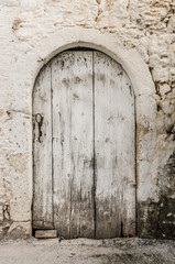 Old white timber door in the scuffed wall