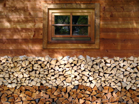 Brennholz aufgeschichtet am Haus aus Holz 
