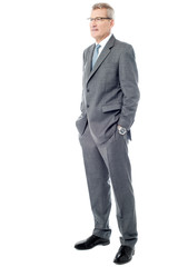 Experienced businessman with hands in pockets