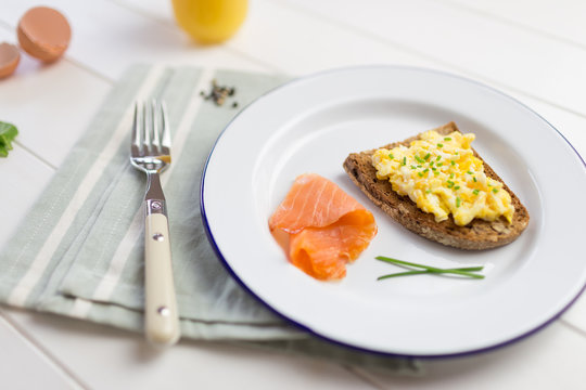 Smoked salmon close-up with scrambled eggs with chives