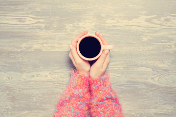 Female hands holding cup of coffee.