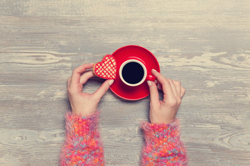Female hands holding cup of coffee.