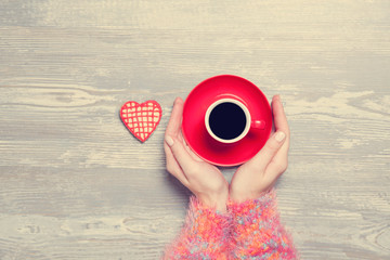 Female hands with cup of coffee and cookie.