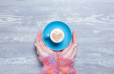 Female hands holding cup of coffee.