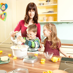 Junge Eltern backen in der Küche mit ihren Kindern