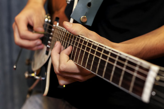 electric guitar close-up with fingers playing it
