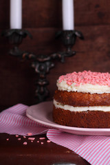 Banana cake with nuts and cream decorated with pink drops