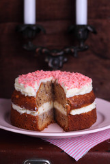 Banana cake with nuts and cream decorated with pink drops