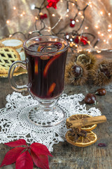 Mulled wine, mince pies and spices on wooden background