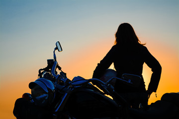 classic motorcycle and girl silhouette at sunset