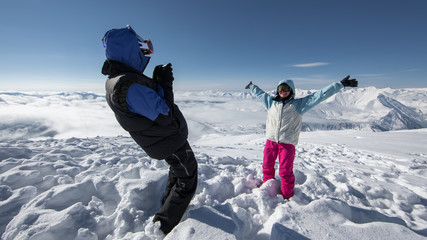 Hiker posing at top of snowy mountain during sunny day