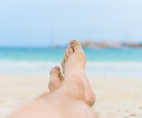 Man sunbathing on the beach. Legs.