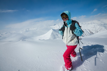 Fototapeta na wymiar Hiker posing at top of snowy mountain during sunny day
