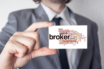 Broker. Businessman in suit with a black tie showing business ca