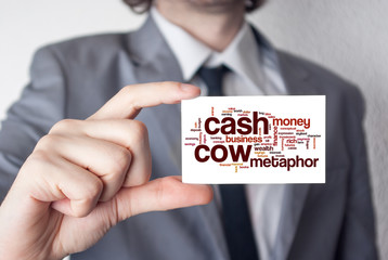 Cash cow. Businessman in suit with a black tie showing or holdin
