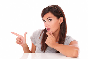 Pensive sexy woman pointing to her right