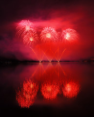 Beautiful red fireworks reflecting in water - 72575185
