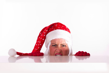 Frau mit Weihnachtsmütze beißt auf Tischkante - isoliert