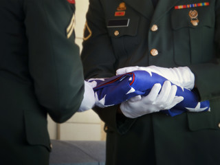 Guard Folds United States Flag at Veteran Funeral