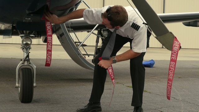 Pilot Attaches Ribbons to Aircraft (Remove Before Flight)