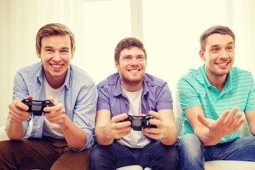 smiling friends playing video games at home
