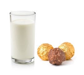 Glass of milk and chocolate ball isolated on white
