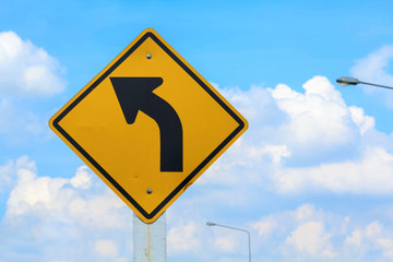 Winding road sign on blue sky