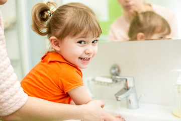 mother washing kid hands