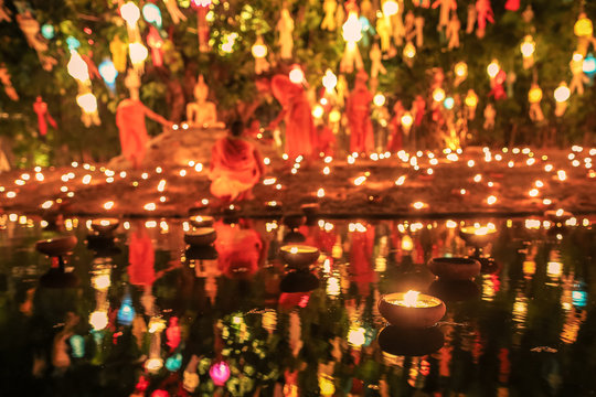 Floating candle with monk and buddha image in Thai temple