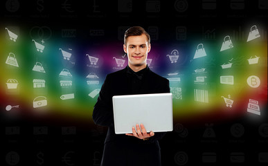 Smiling young man standing with laptop