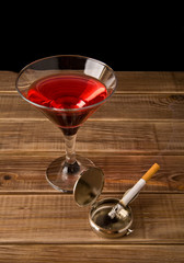 cigarette in an ash-tray and glass of wine