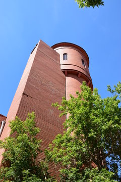 A red- brick tower with some greenery