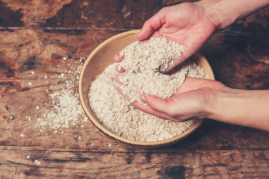 Hands mixing oats on table