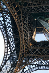 Angle view below Eiffel Tower on sunset