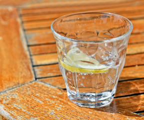 Glass with sparkling water, ice cubes and lemon