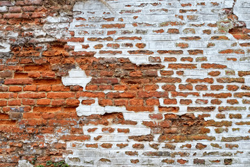 Wall built of red bricks with white painting