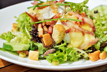 Salad with hot goat cheese, ham and vegetables