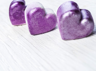 Obraz premium Violet hearts wooden background,