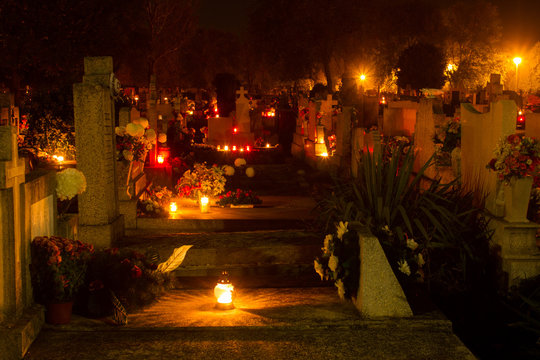 cemetery decorated with candles for All Saints Day at night